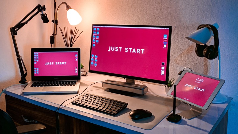 Computer screens saying "Just start" on the desktop background